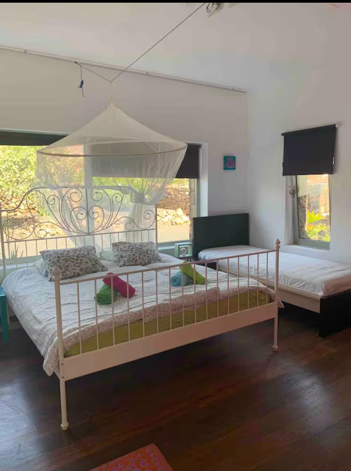 Helles Schlafzimmer mit Himmelbett und Gartenblick